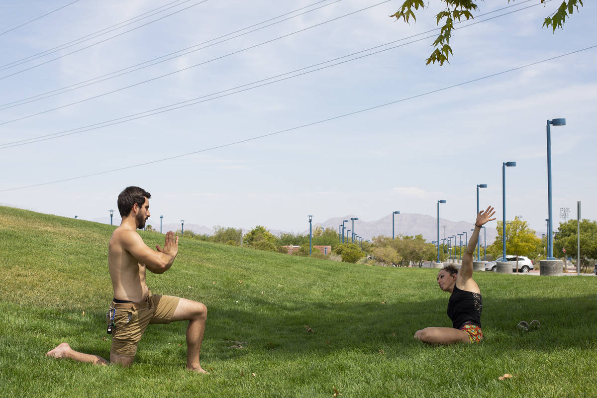 Tyler Bryce, left, and Natalie Kleinman, right, practice yoga despite an excessive heat warning ...