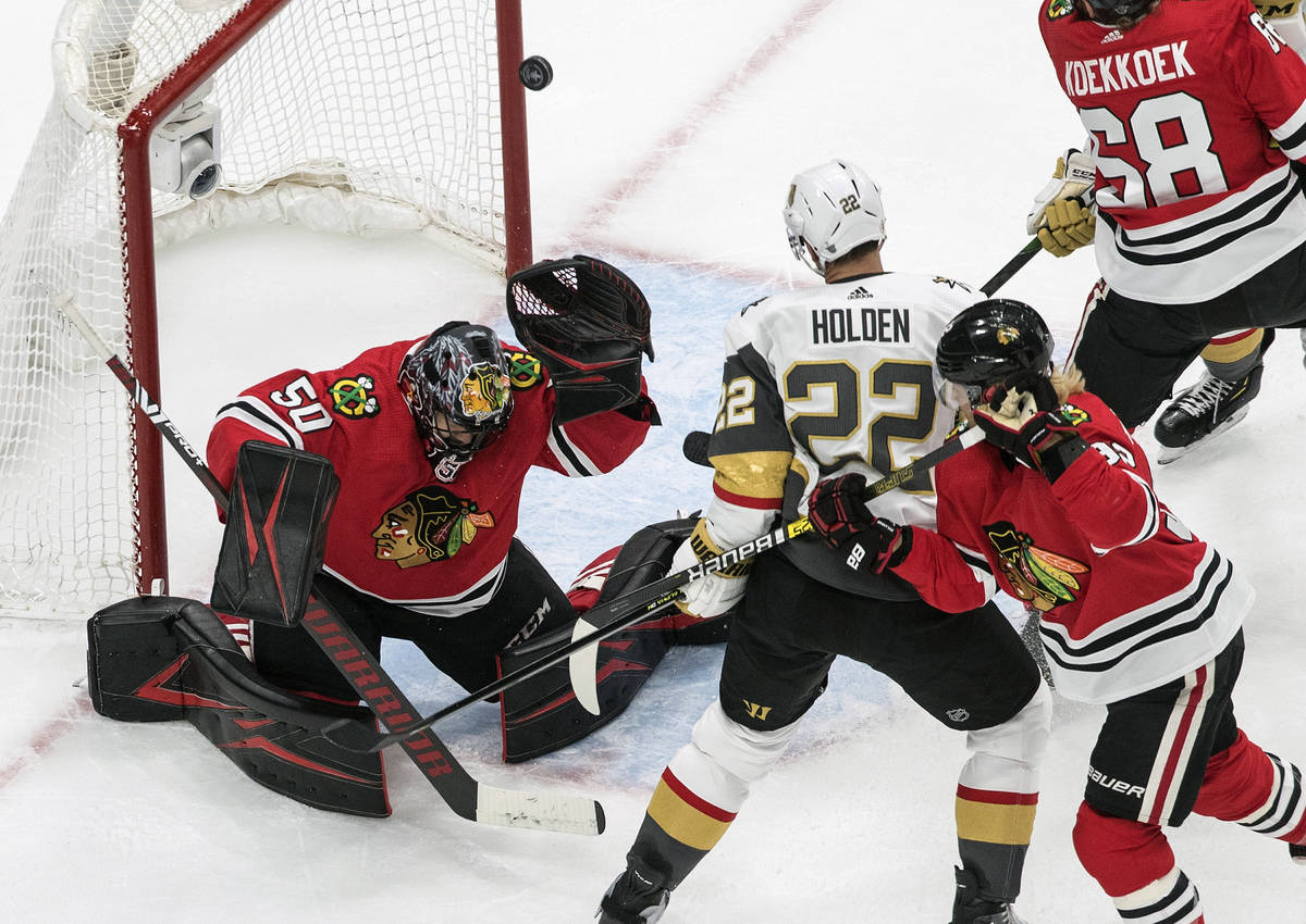 Vegas Golden Knights' Nick Holden (22) is stopped by Chicago Blackhawks' goalie Corey Crawford ...