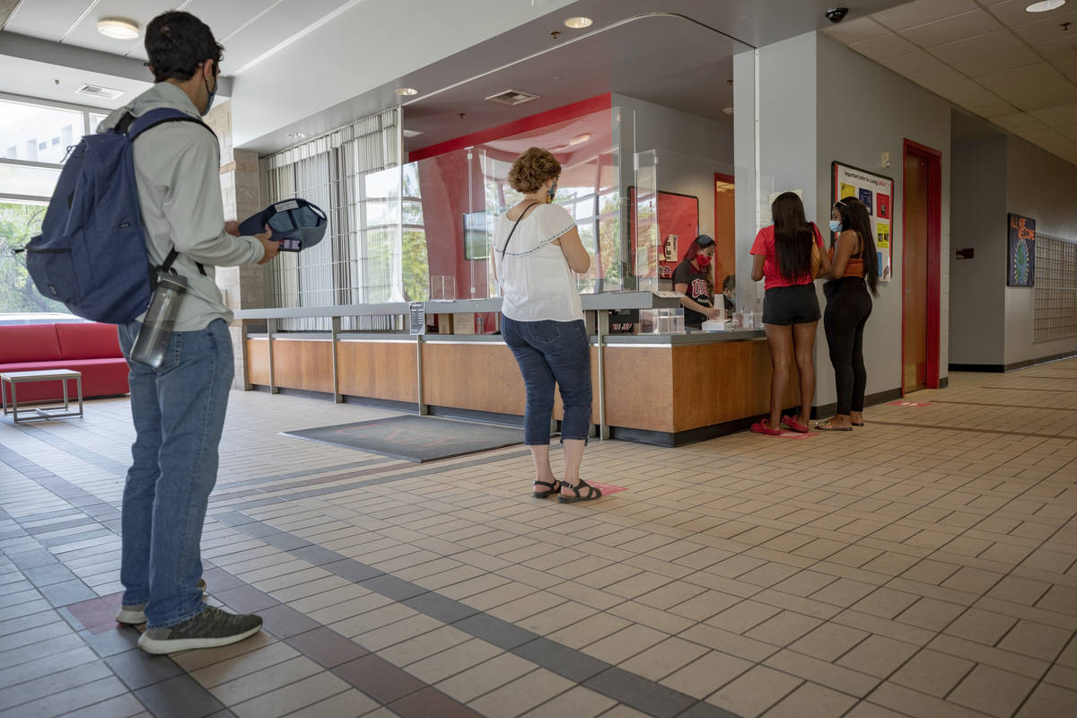 Individuals check-in at Dayton Hall during freshman move-in day at UNLV in Las Vegas on Monday, ...