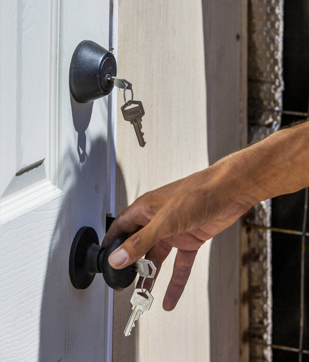 Robert Majors makes sure the keys work on a new hut for the homeless joined by other with other ...