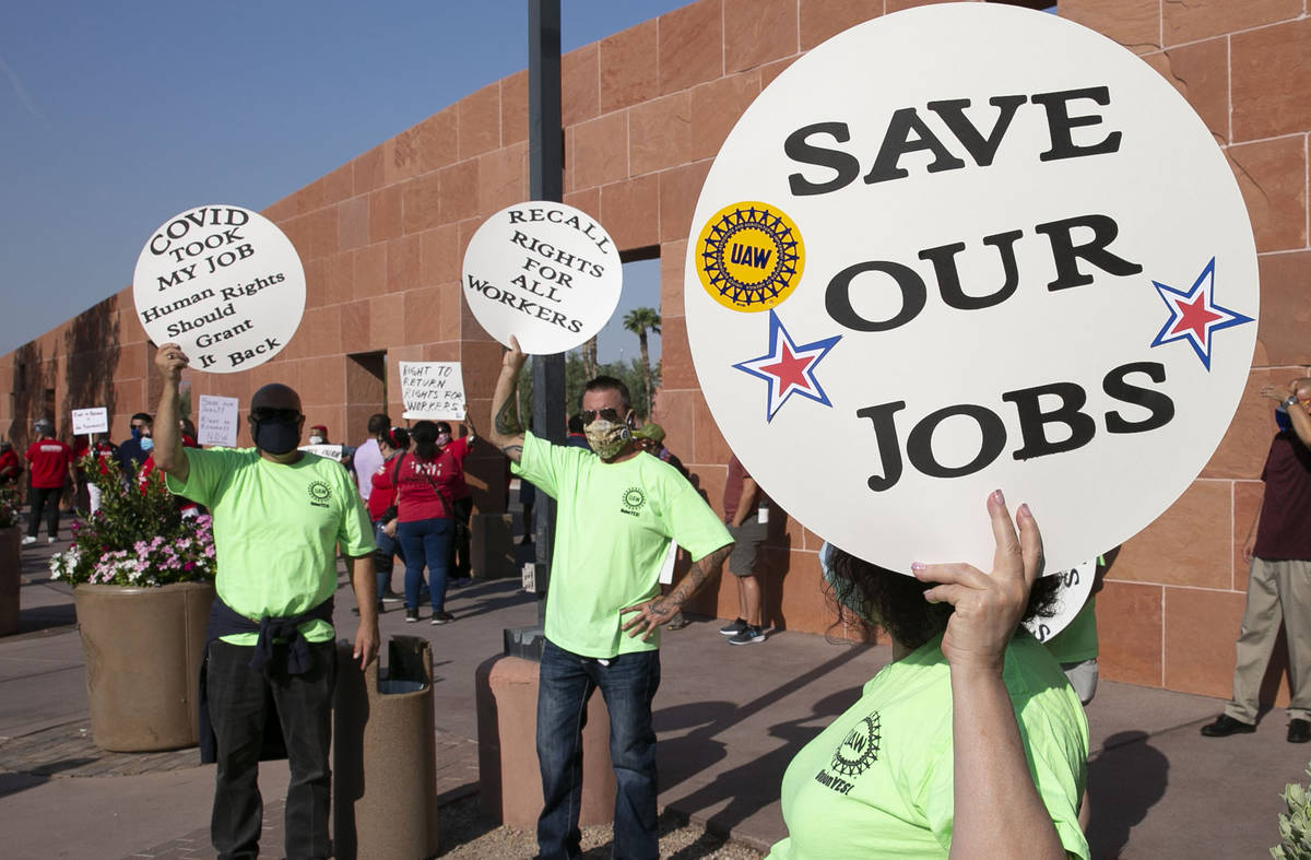 Alex Santana, left, Jim Soldate and Donna Blair, right, rally outside of the Clark County Commi ...