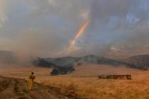 Retired Cal Fire captain Dan Dinneen, of Clayton, Calif., stops to take a picture of a rainbow ...