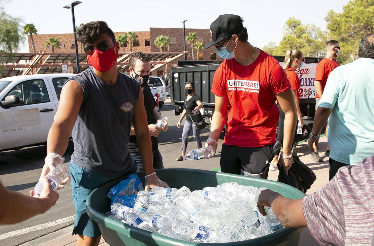 Volunteers Christopher Hughes, left, and his brother Declan hand out bottles of water to union ...
