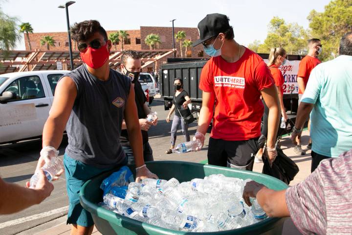 Volunteers Christopher Hughes, left, and his brother Declan hand out bottles of water to union ...