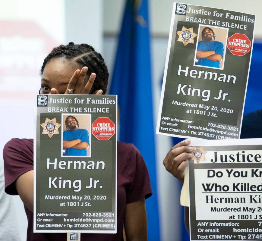 A relative of Herman King Jr. holds a sign while wiping tears from her eyes during a press brie ...