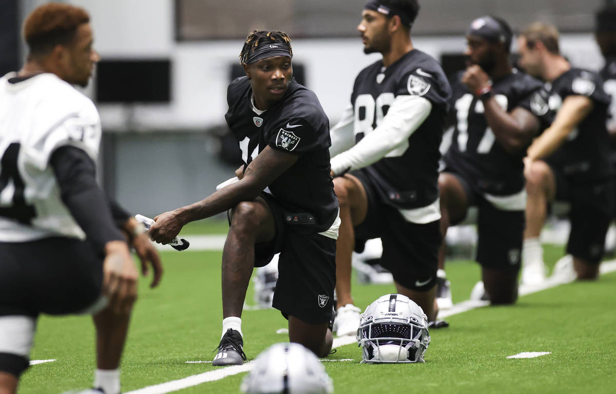 Las Vegas Raiders wide receiver Henry Ruggs III (11) stretches with teammates during an NFL tra ...