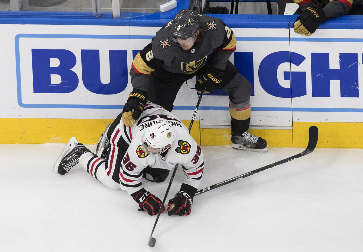 Vegas Golden Knights' Zach Whitecloud (2) checks Chicago Blackhawks' Matthew Highmore (36) duri ...