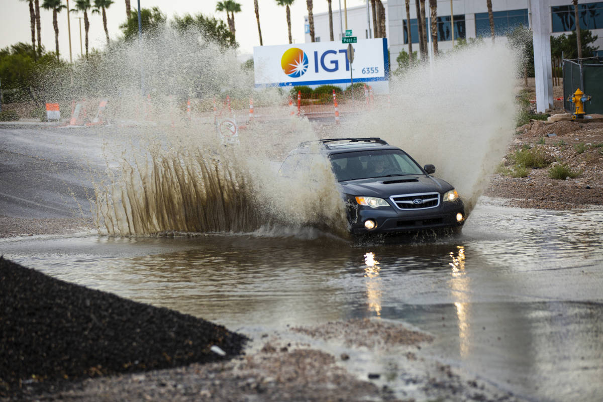 Cars move through a flooded portion of Buffalo Drive near Post Road in Las Vegas on Wednesday, ...