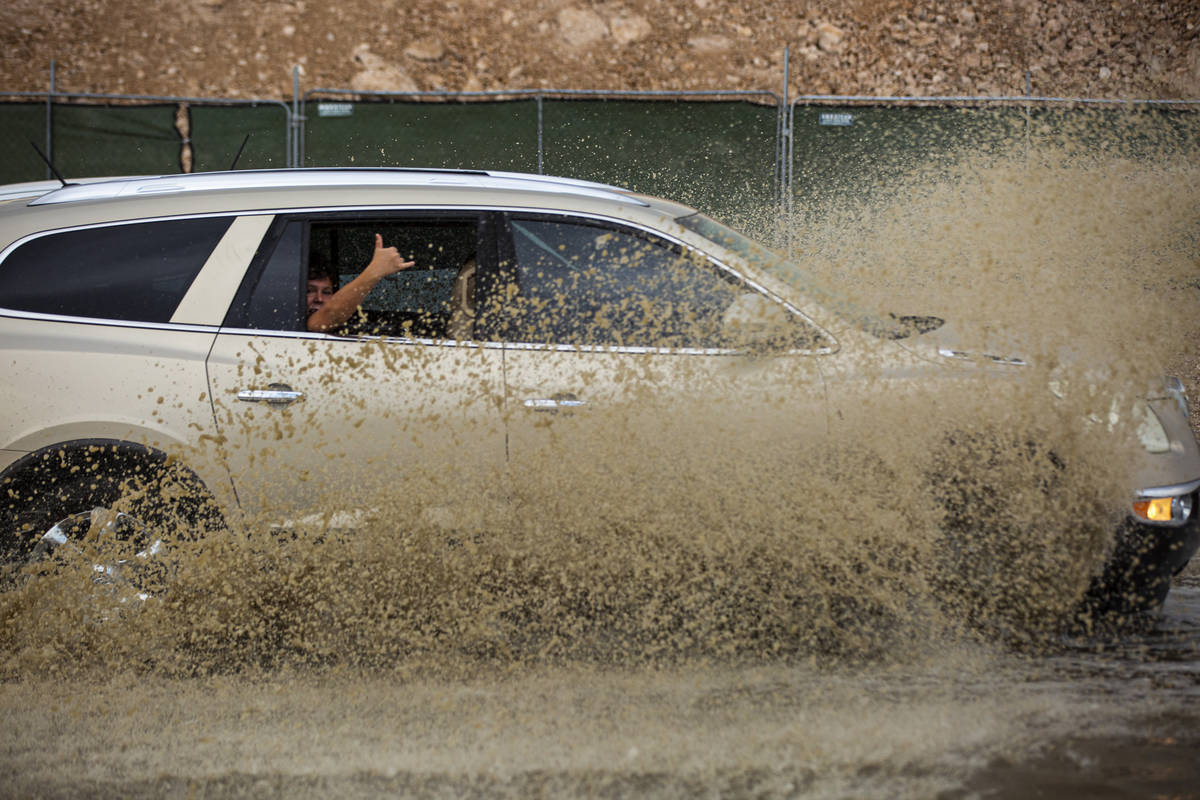 Cars move through a flooded portion of Buffalo Drive near Post Road in Las Vegas on Wednesday, ...