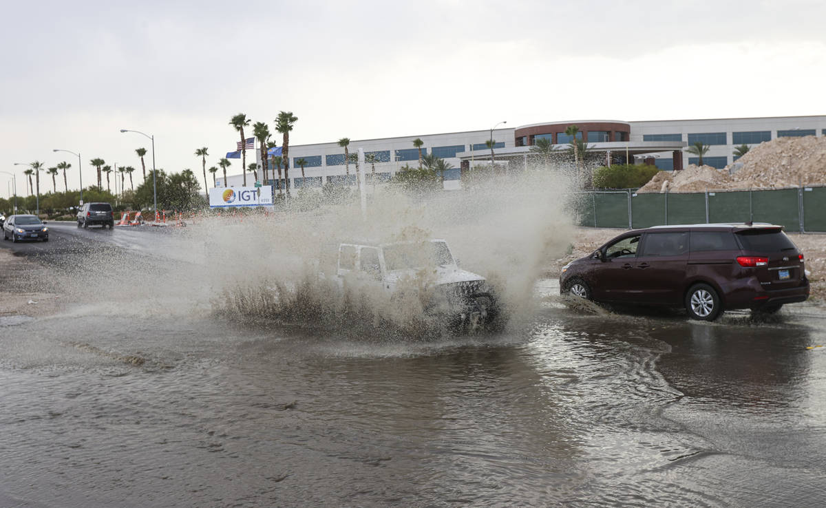 Cars move through a flooded portion of Buffalo Drive near Post Road in Las Vegas on Wednesday, ...