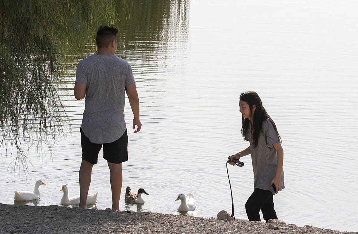A couple, who declined to give their names, walk their dog early morning to beat the heat at Co ...