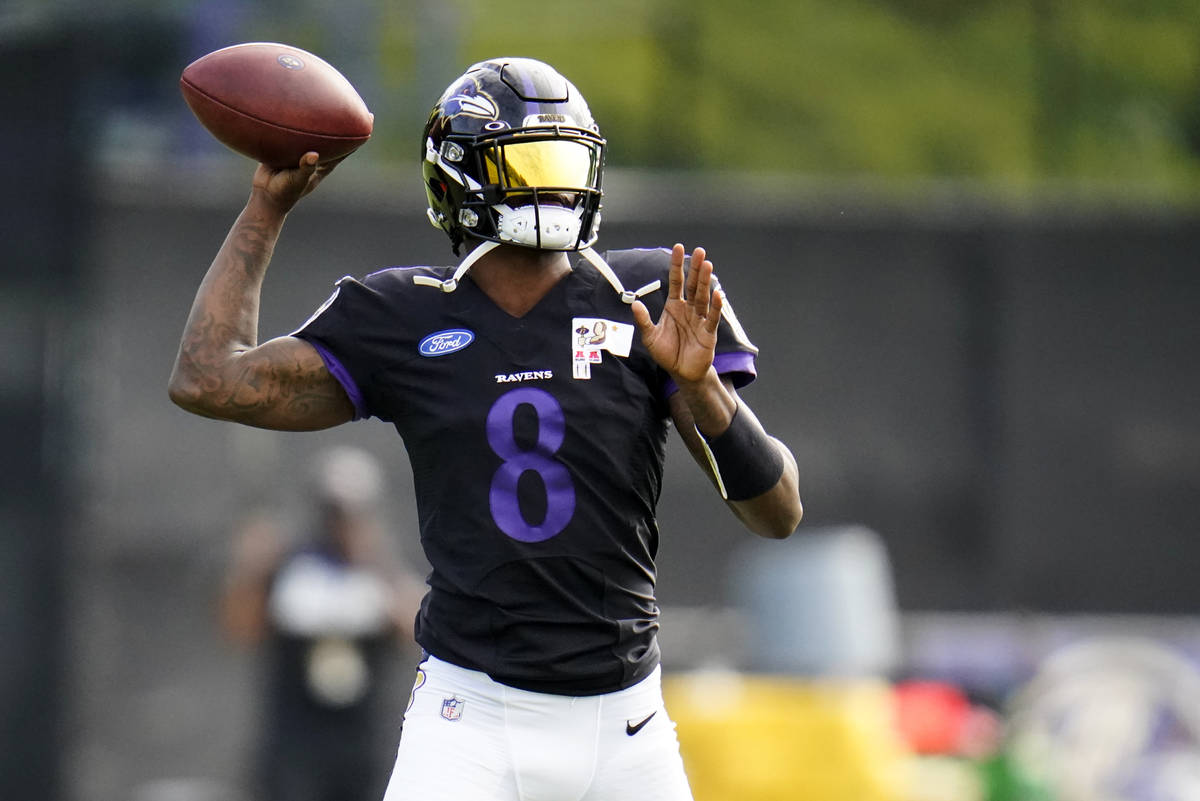 Baltimore Ravens quarterback Lamar Jackson works out during an NFL football camp practice, Mond ...