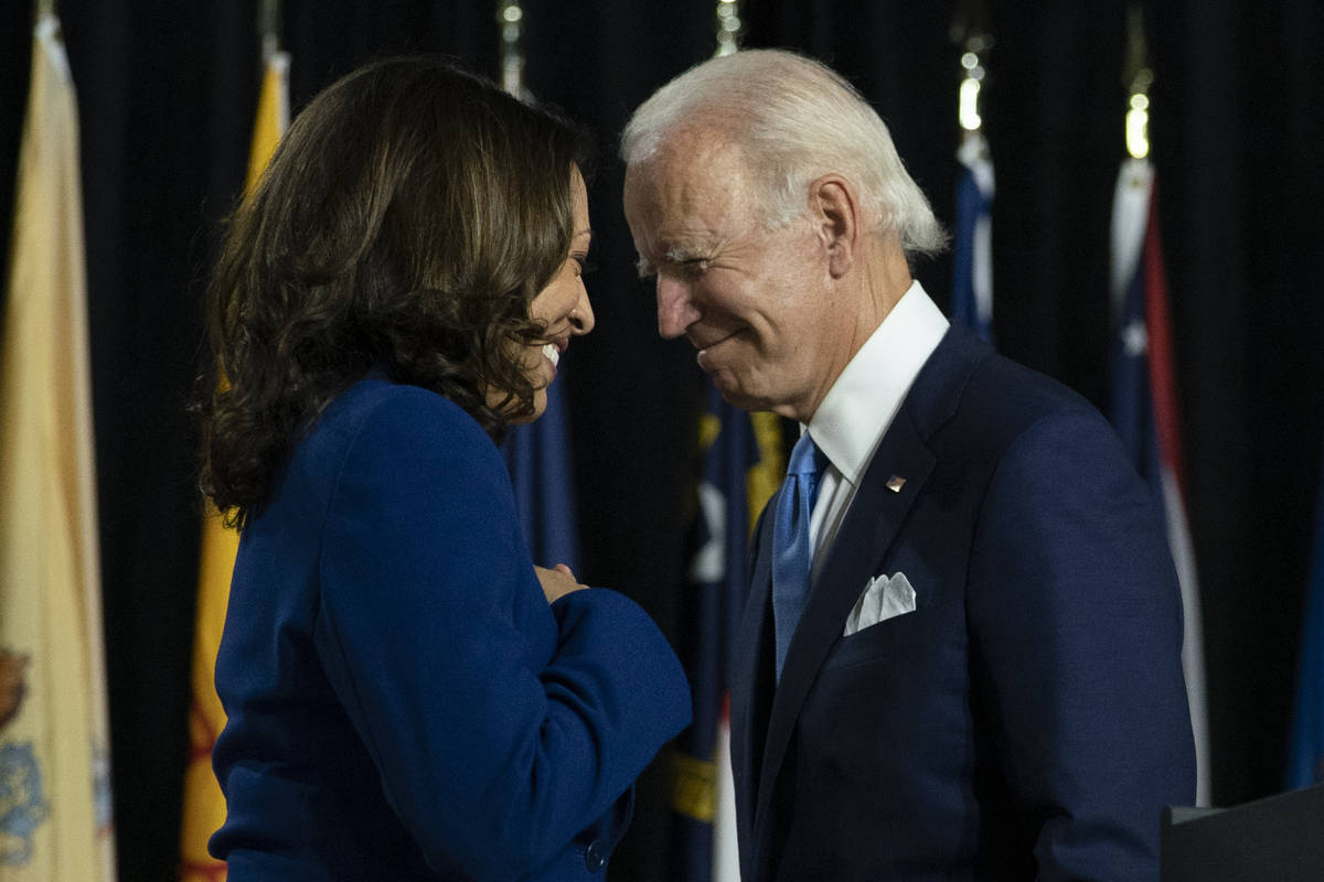 Former Vice President Joe Biden and his running mate Sen. Kamala Harris, D-Calif., pass each ot ...