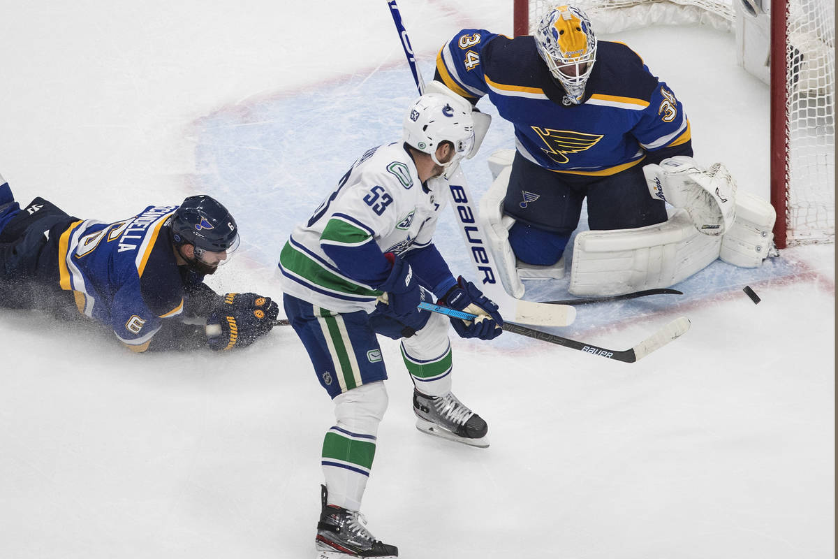 St. Louis Blues goalie Jake Allen (34) makes the save on Vancouver Canucks' Bo Horvat (53) as M ...
