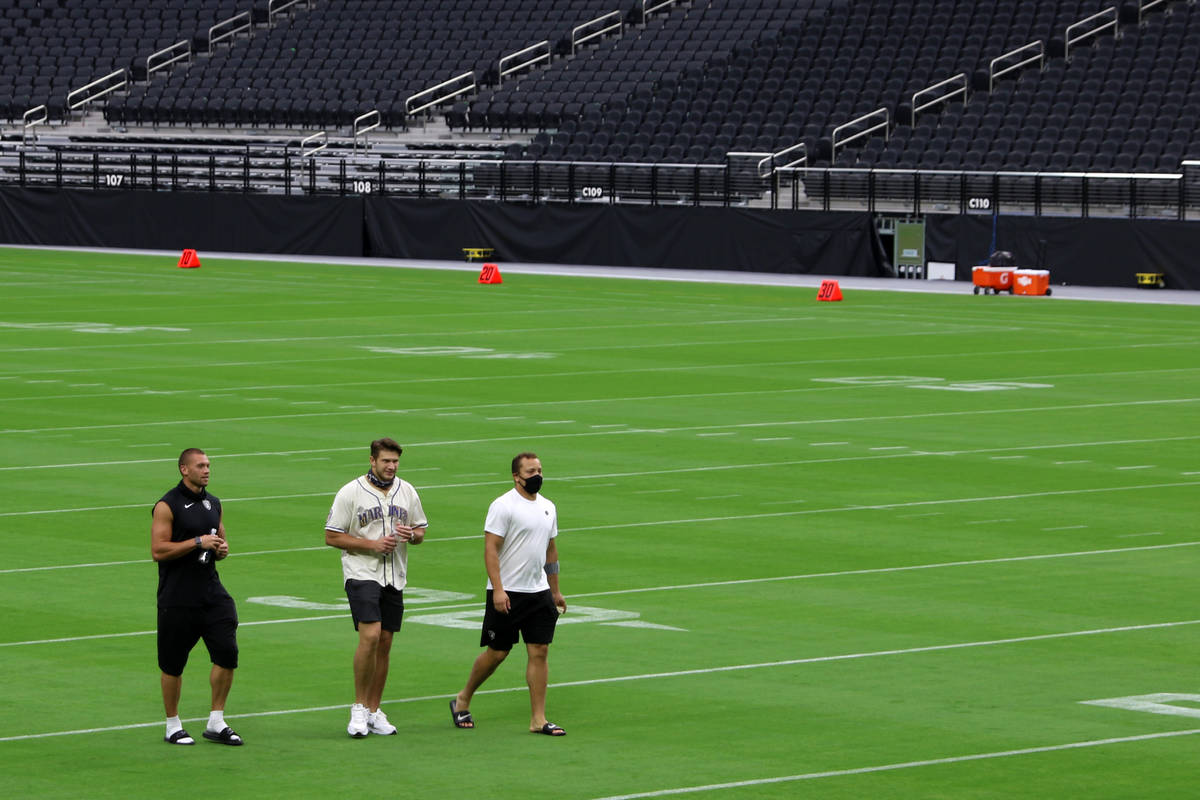 Derek Carrier, Foster Moreau and Alec Ingold walk the field prior to a Las Vegas Raiders team p ...