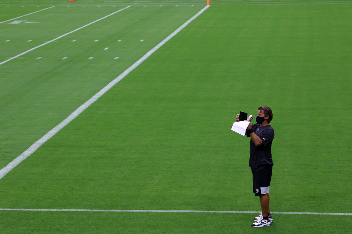 Raiders offensive coordinator Greg Olson takes photos prior a Las Vegas Raiders team practice a ...