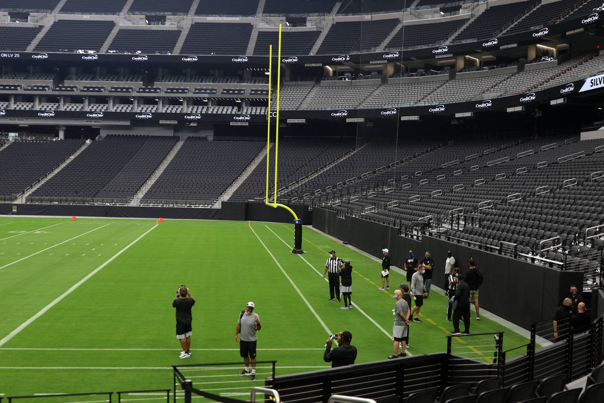 Raiders staff take a look at the field prior to a Las Vegas Raiders team practice at Allegiant ...
