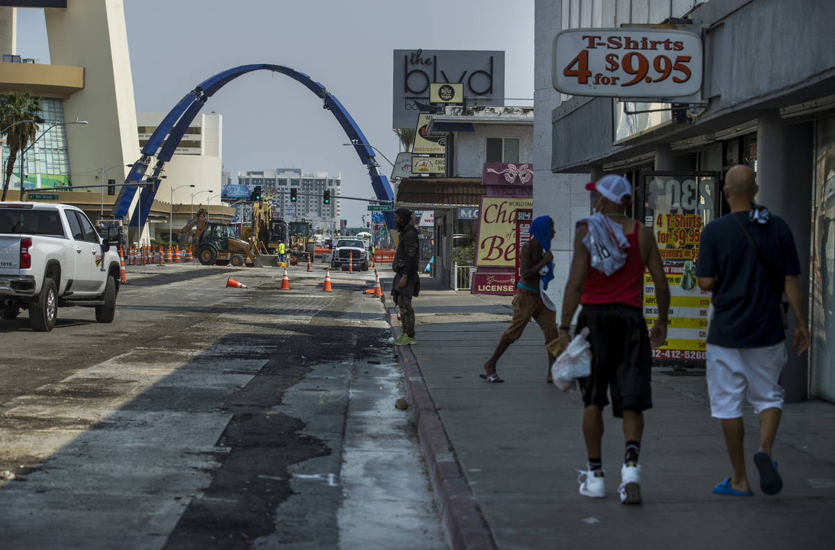 Pedestrians walk towards the construction of the 80-foot-tall gateway arch over Las Vegas Boule ...