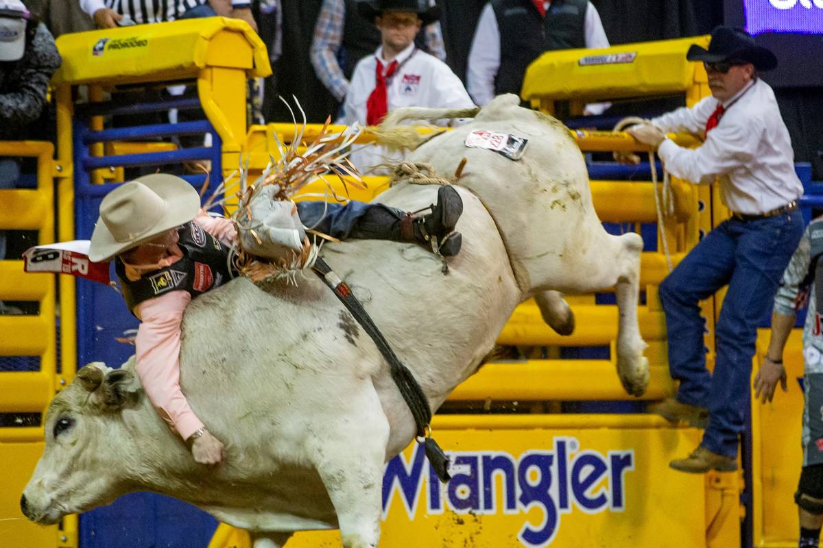 Clayton Sellars of Fruitland Park, Fla., clings to his ride in Bull Riding at the tenth go roun ...