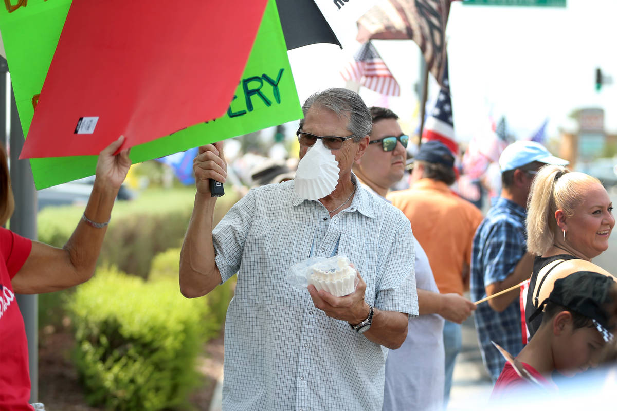 Bill Henggeler of Henderson, 72, wears a coffee filter on his face while attending a No Mask Ne ...