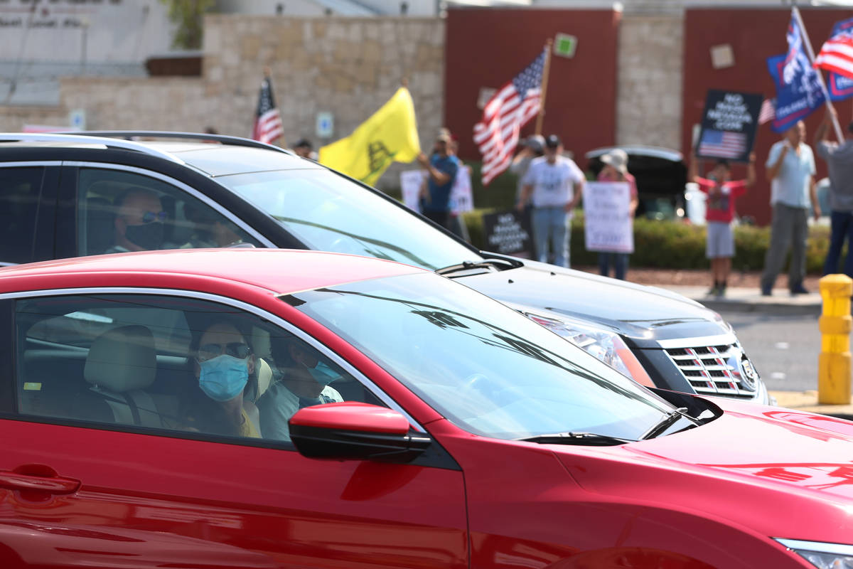 People in their cars look out to a No Mask Nevada PAC rally at the intersection of Eastern Aven ...