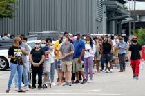 People line up to enter retail chain Costco to buy provisions in New Orleans, Sunday, Aug. 23, ...
