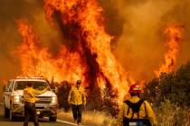 Flames from the LNU Lightning Complex fires leap above Butts Canyon Road on Sunday, Aug. 23, 20 ...