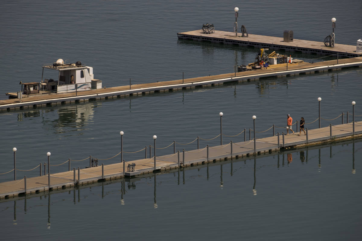 A couple walks along a dock at the Lake Mead Marina about the Lake Mead National Recreation Are ...
