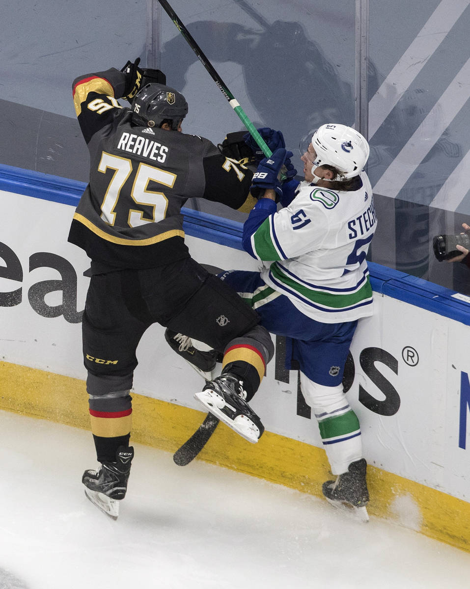 Vegas Golden Knights' Ryan Reaves (75) checks Vancouver Canucks' Troy Stecher (51) during the f ...