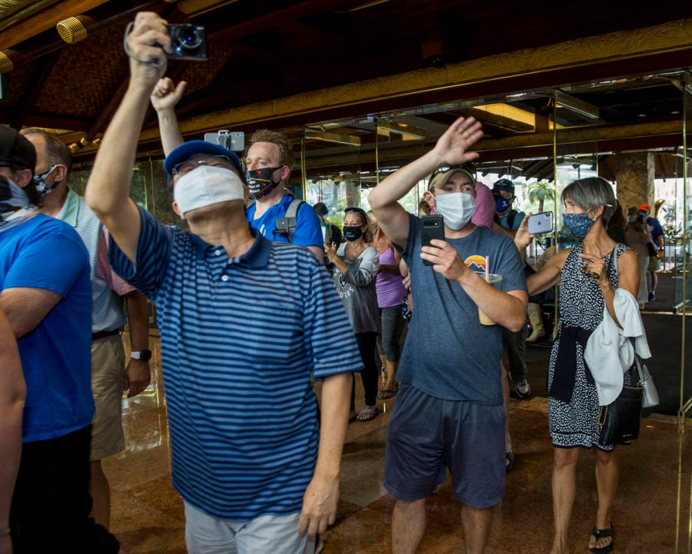 Guests celebrate and document while entering the front doors as the Mirage reopens following a ...