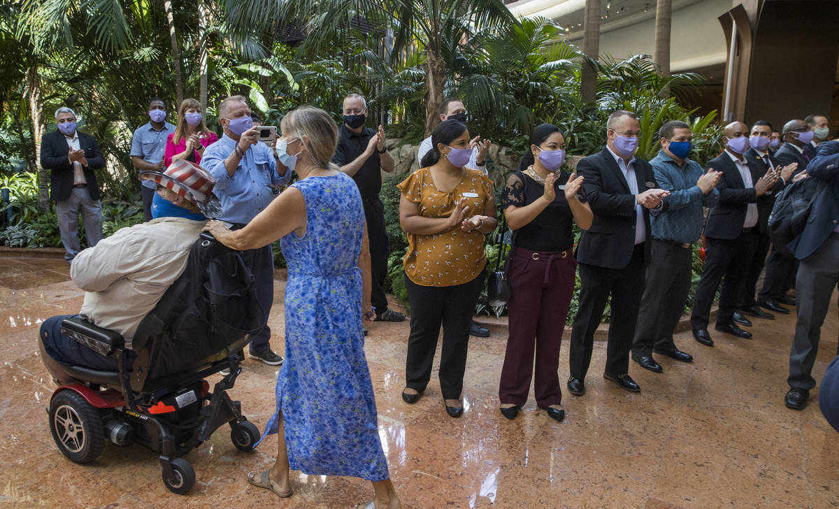 Employees applaud while greeting guests entering the front doors as the Mirage reopens followin ...