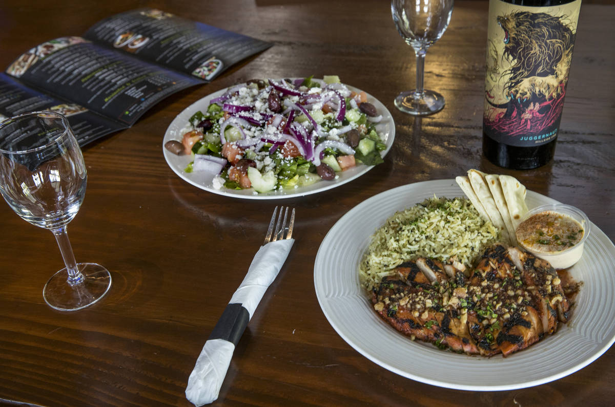 Pomegranate Chicken, right, and Greek Salad dishes with wine from the Market Grille Cafe which ...