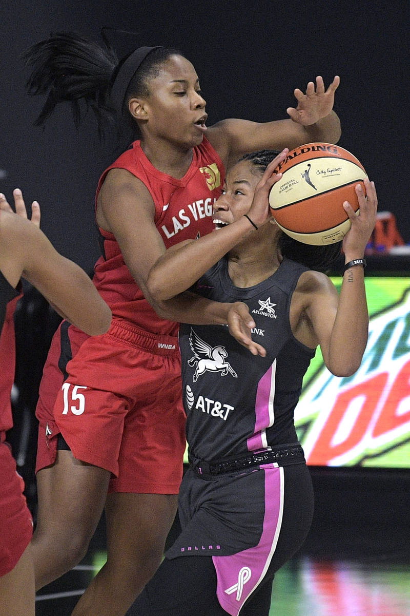 Dallas Wings guard Tyasha Harris, right, is fouled by Las Vegas Aces guard Lindsay Allen, left, ...
