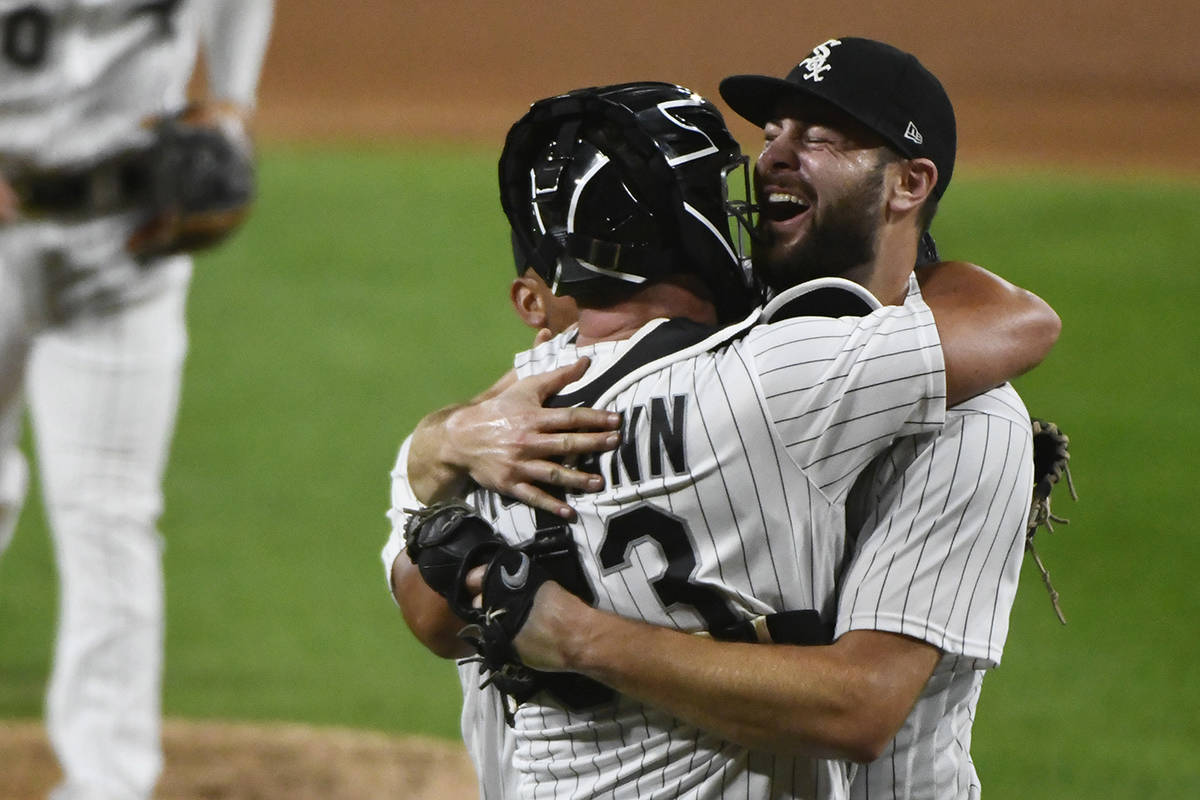 Chicago White Sox starting pitcher Lucas Giolito, right, hugs catcher James McCann and Jose Abr ...
