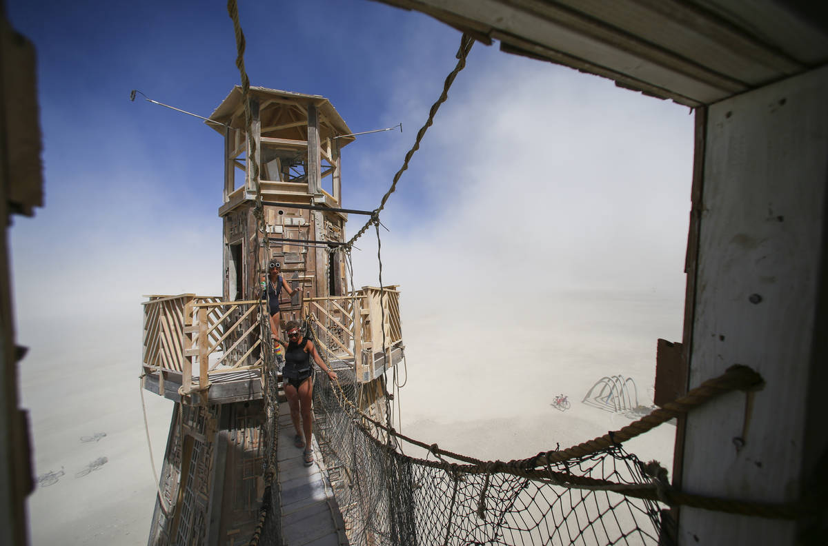 Attendees explore The Black Rock Lighthouse Service art installation during Burning Man at the ...