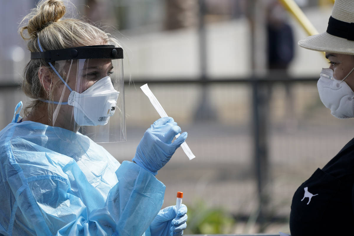 FILE - In this Aug. 13, 2020, file photo, nurse practitioner Debbi Hinderliter, left, collects ...