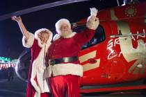 Santa and Mrs. Claus wave to attendees from their Papillon Grand Canyon Helicopter after landin ...