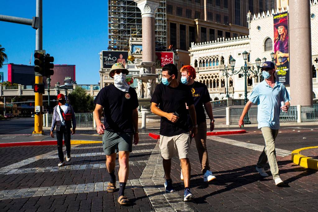 People wearing masks walk along the Las Vegas Strip on Friday, July 17, 2020. (Chase Stevens/La ...
