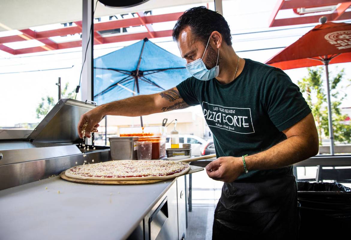 Mimmo Ferraro, owner and chef at Pizza Forte, right, prepares a pizza in the University Gateway ...