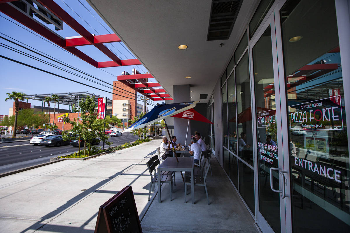 People dine on the patio at Pizza Forte in the University Gateway Building off of Maryland Park ...
