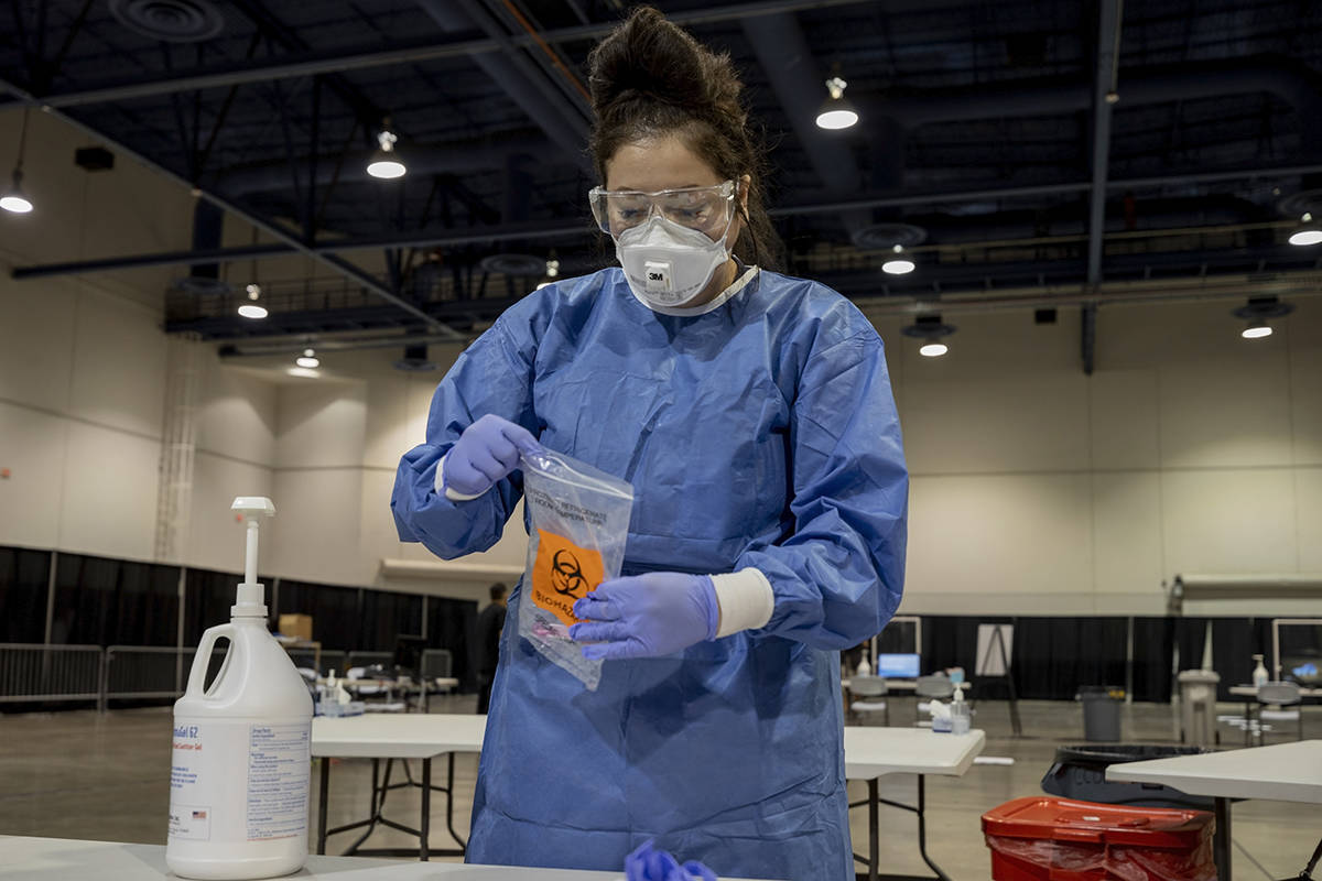 UMC respiratory therapist Diana Vega seals a COVID-19 test in a biohazard bag during a preview ...