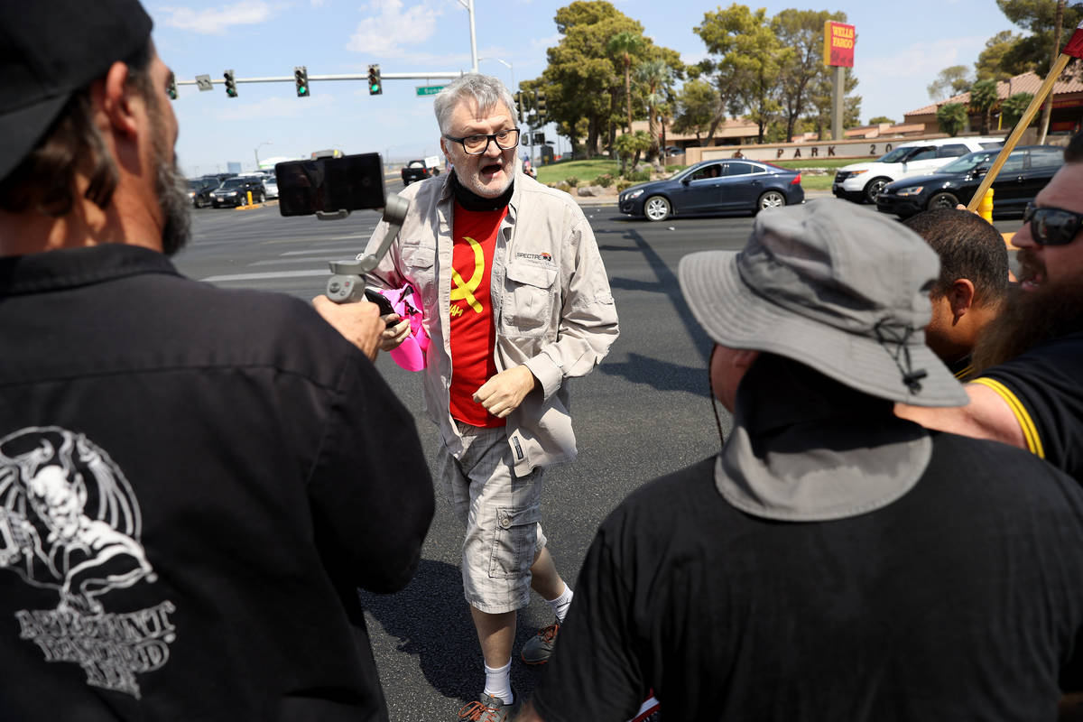 A counterprotester is confronted by people participating in a No Mask Nevada PAC rally at Sunse ...
