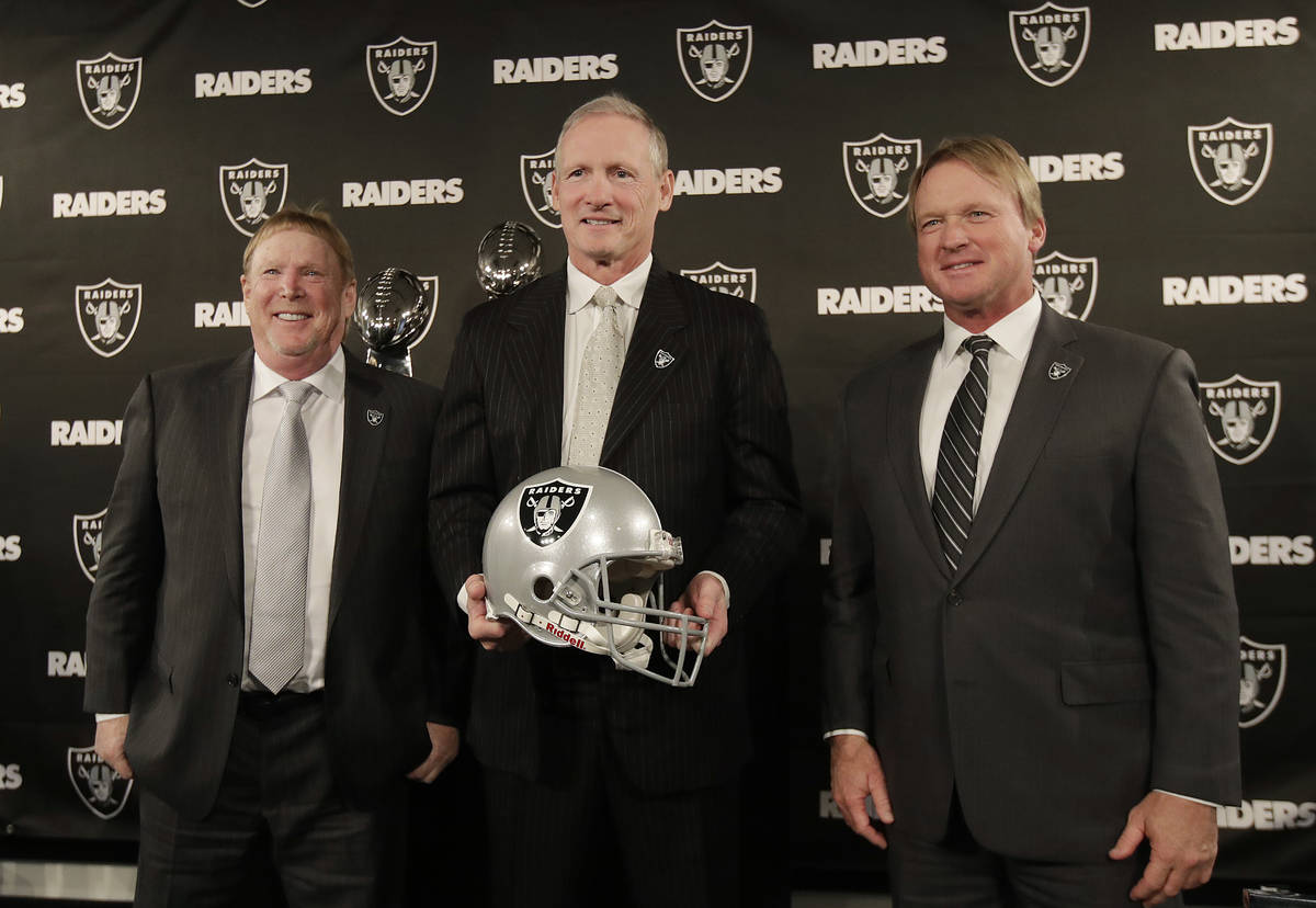 Mike Mayock, center, poses for photos with Oakland Raiders owner Mark Davis, left, and head coa ...