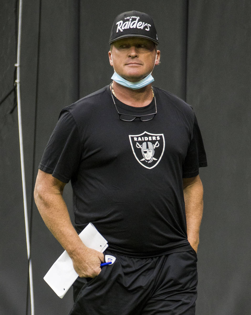 Las Vegas Raiders head coach Jon Gruden watches players on the field warming up for a scrimmage ...