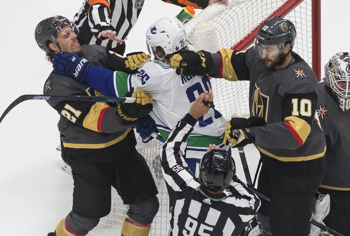 Vancouver Canucks' Antoine Roussel (26) and Vegas Golden Knights' Nick Cousins (21) and Nicolas ...