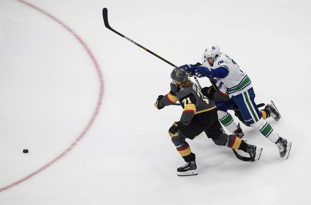 Vancouver Canucks' Tanner Pearson (70) and Vegas Golden Knights William Karlsson (71) battle fo ...