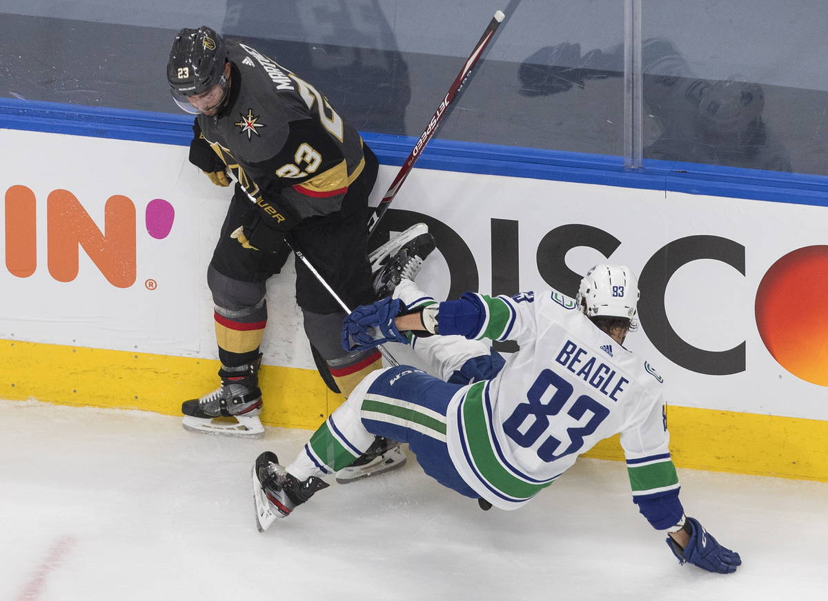 Vancouver Canucks' Christopher Tanev (83) is checked by Vegas Golden Knights' Alec Martinez (23 ...
