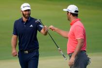 Jon Rahm, right, is congratulated by Dustin Johnson on the first playoff hole during the final ...