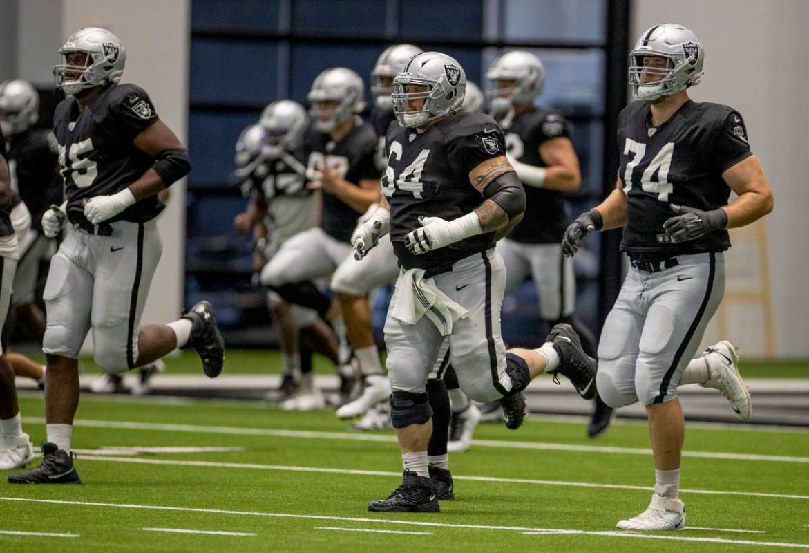 Las Vegas Raiders guard Richie Incognito (64, center) runs sprints beside teammate offensive ta ...