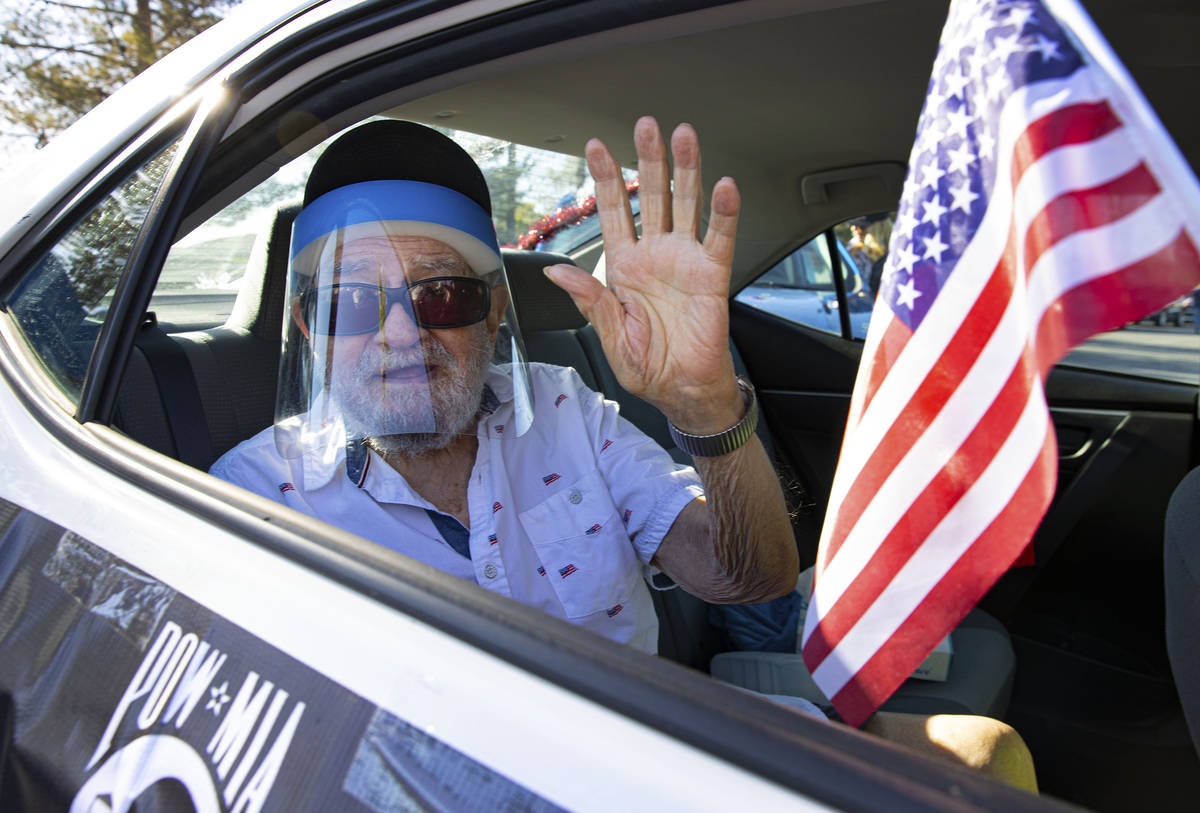 1st Lt. Vincent Shank, a 103-year-old World War II veteran, waves during the procession for the ...
